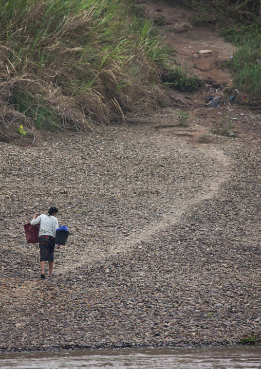 Khmu minority woman carrying water from mekong river, Xieng khouang, Laos