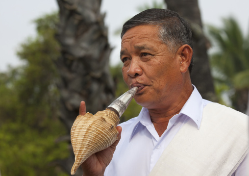 Man blowing in shell  during pii mai lao new year celebration, Luang prabang, Laos