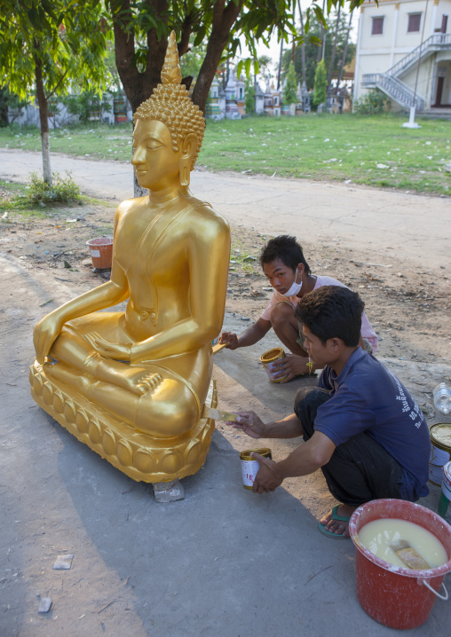 Men painting a buddha statue, Savannakhet, Laos