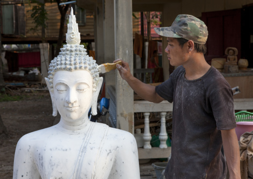 Man painting a buddha statue, Savannakhet, Laos