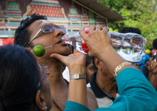 Woman Giving Water To An Hindu Devotee In Annual Thaipusam Religious Festival In Batu Caves, Southeast Asia, Kuala Lumpur, Malaysia