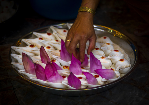 Woman Putting Flowers Petals On Shells For A Religious Offering, Malacca, Malaysia