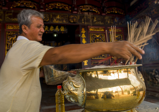 Man Putting Incense Sticks In Cheng Hoon Teng Temple, Malacca, Malaysia