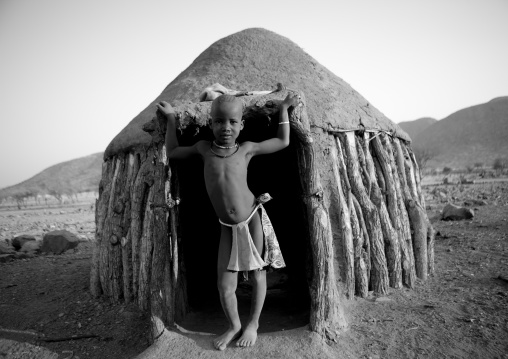 Himba Boy In The Entrance Of His Hut, Okapale Area, Namibia