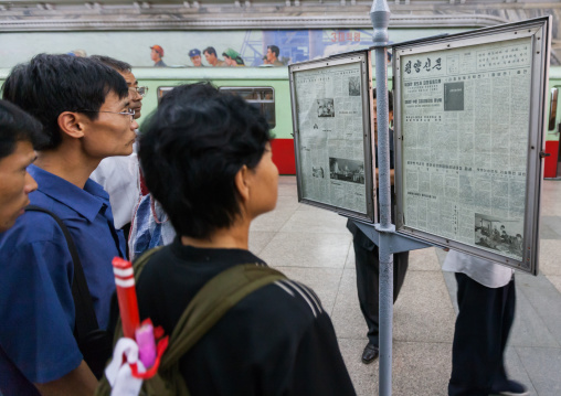 North Korean people reading the offical state newspaper in a subway station, Pyongan Province, Pyongyang, North Korea