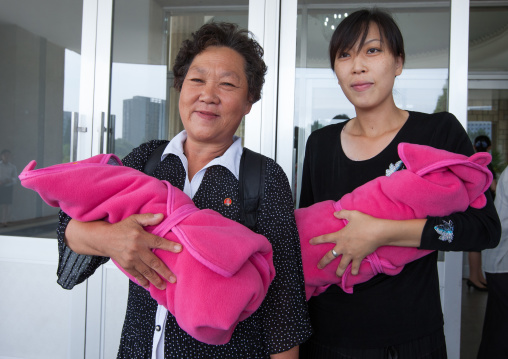 Mother and Grand mother coming out of the maternity hospital with babies, Pyongan Province, Pyongyang, North Korea