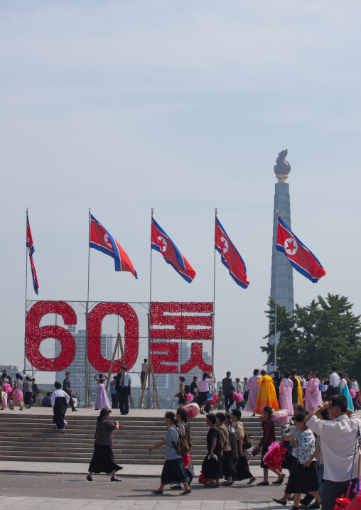 North Korean people with plastic bunches of red flowers celebrating the 60th anniversary of the regim, Pyongan Province, Pyongyang, North Korea