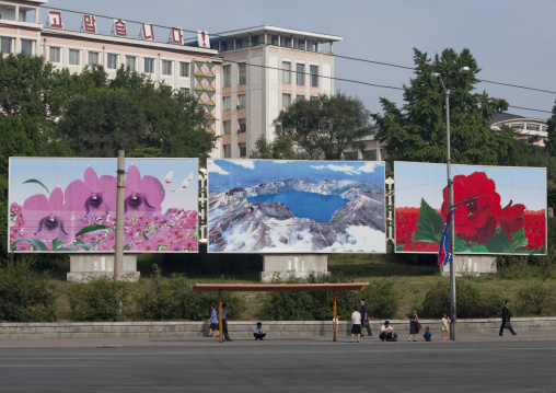 North Korean people waiting for the bus under some propaganda billboards with mount Paektu, Pyongan Province, Pyongyang, North Korea
