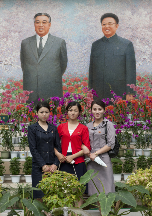North Korean women posing in front of the Dear Leaders fresco at the international Kimilsungia and Kimjongilia festival, Pyongan Province, Pyongyang, North Korea