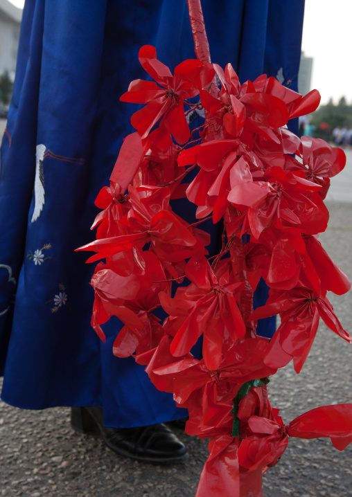 North Korean woman with plastic flowers during the september 9 parade, Pyongan Province, Pyongyang, North Korea