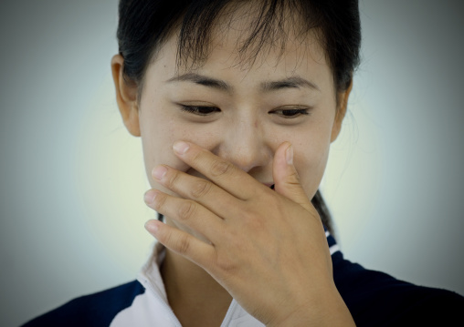 Shy North Korean woman with her hand on her mouth, Pyongan Province, Pyongyang, North Korea