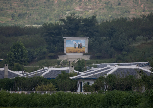 Giant fresco with the Dear Leaders above a village in the countryside, North Hwanghae Province, Sariwon, North Korea