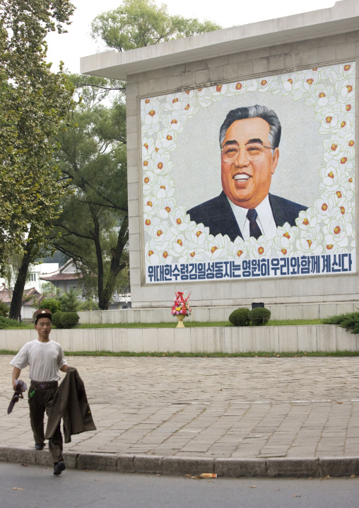 North Korean soldier running in front of a Kim il Sung fresco, North Hwanghae Province, Sariwon, North Korea