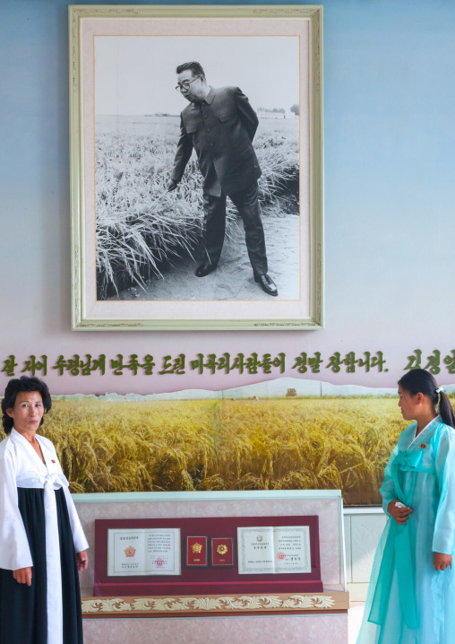 North Korean women in front of a Kim il Sung picture in a museum, Kangwon Province, Chonsam Cooperative Farm, North Korea