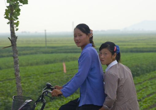 North Korean girls on their bicycles in the countryside, Kangwon Province, Chonsam Cooperative Farm, North Korea