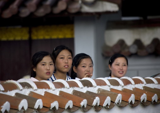 North Korean women looking above a wall, North Hwanghae Province, Sariwon, North Korea