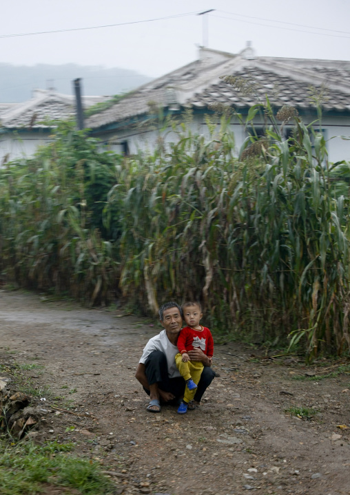 North Korean man with his son in the countryside, North Hwanghae Province, Sariwon, North Korea