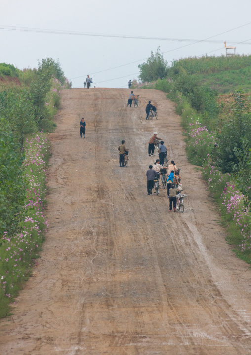 North Korean people pushing their bicycles on a sloping road, North Hwanghae Province, Kaesong, North Korea