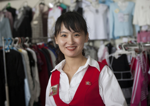 Smiling North Korean woman selling clothes in a shop, Pyongan Province, Pyongyang, North Korea