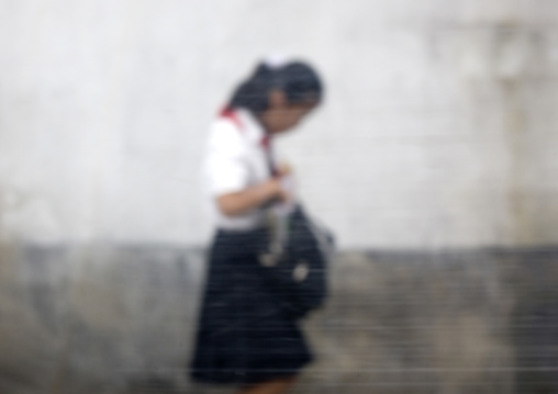 North Korean pioneer girl in the street seen thru a bus glass, Pyongan Province, Pyongyang, North Korea