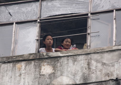 North Korean girls in a decrepit building looking thru a window, Pyongan Province, Pyongyang, North Korea