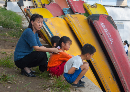 North Korean family in front of rowing boats on Taedong river, Pyongan Province, Pyongyang, North Korea