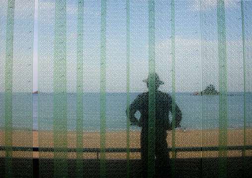 North Korean man on a balcony in front of a beach, North Hamgyong Province, Chilbo Sea, North Korea