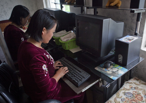 North Korean young woman using a computer at home, South Hamgyong Province, Hamhung, North Korea