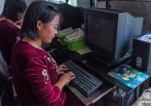 Portrait of a North Korean girl using a computer without electricty during a tourist visit, South Hamgyong Province, Hamhung, North Korea