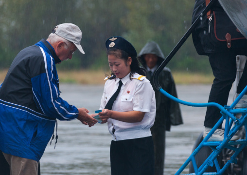 Tourists controled by an airport employee before entering a domestic plane, South Hamgyong Province, Hamhung, North Korea