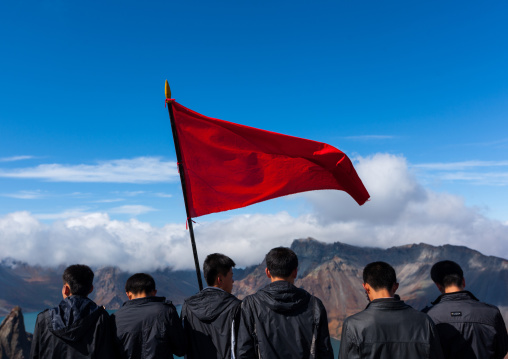 Group of students with red flag in front of lake at mount Paektu, Ryanggang Province, Mount Paektu, North Korea
