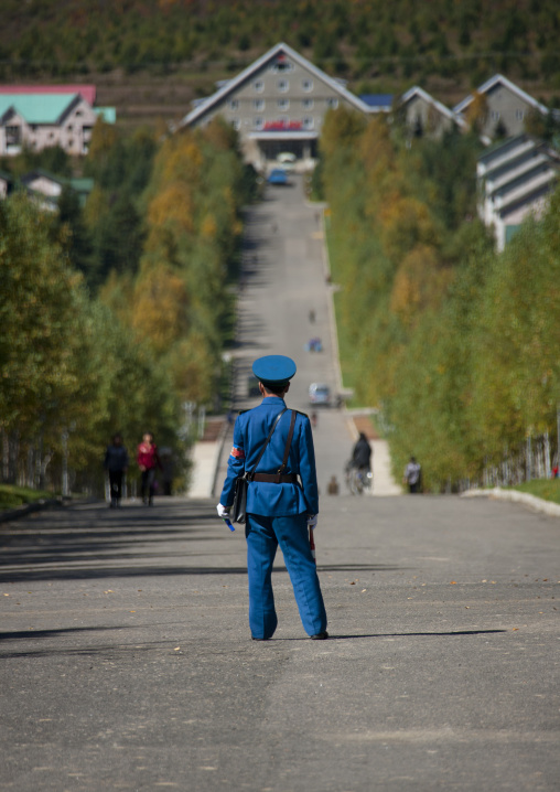 North Korean male traffic security officer in blue uniform in the street, Ryanggang Province, Samjiyon, North Korea