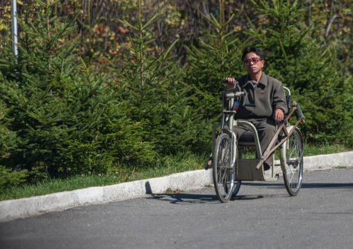 North Korean man with a tricycle wheelchair in the street, Ryanggang Province, Samjiyon, North Korea