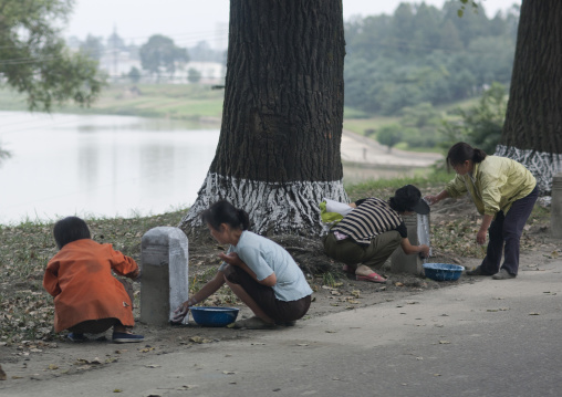 North Korean women cleaning and painting milestones during collective works, Pyongan Province, Pyongyang, North Korea