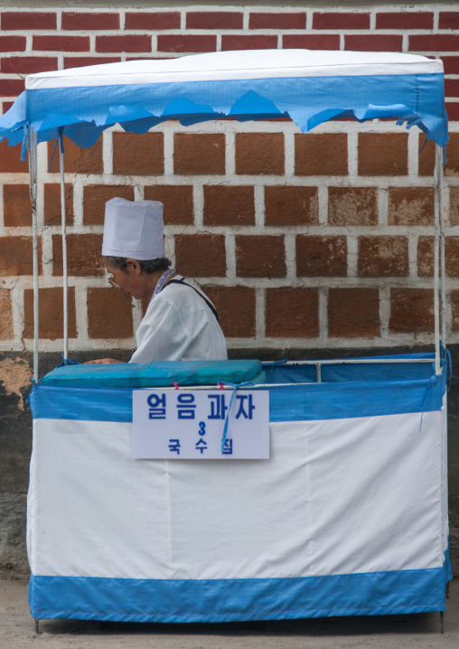 Women selling ice cream and noddles in a stall in the street, North Hwanghae Province, Kaesong, North Korea