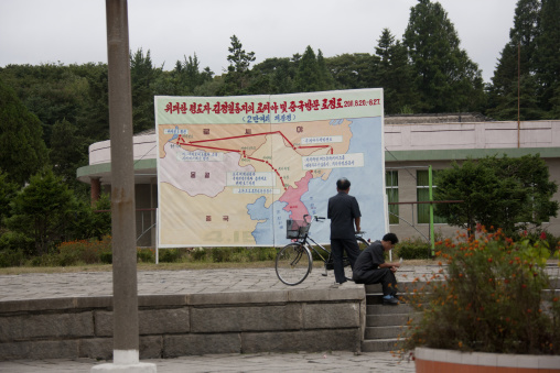 North Korean men in front of the map of the last Kim Jong il trips in train, North Hwanghae Province, Kaesong, North Korea