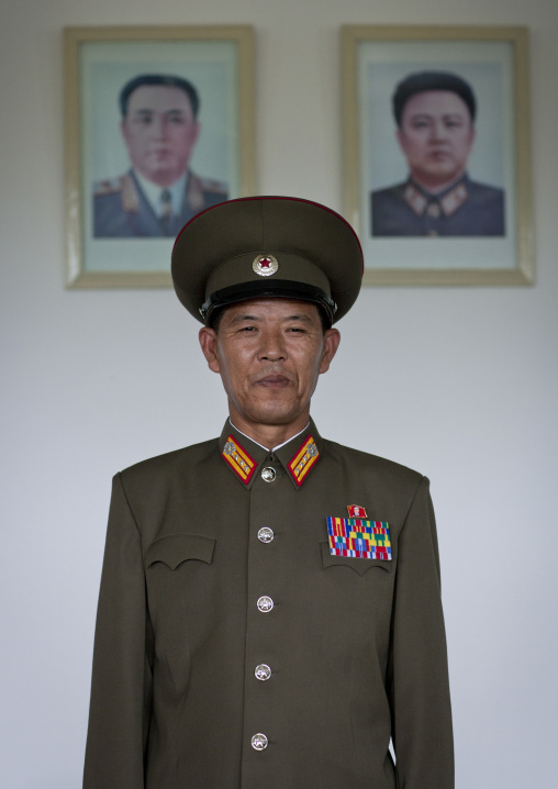 North Korean soldier in the Demilitarized Zone in front of the official portraits of the Dear Leaders, North Hwanghae Province, Panmunjom, North Korea