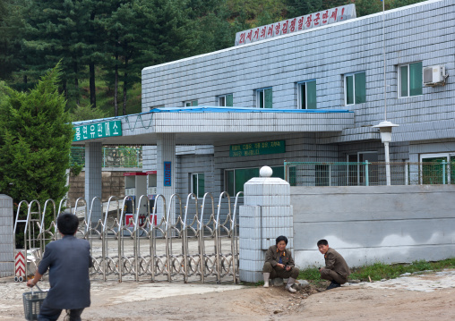 North Korean men resting in front of closed a gas station, Kangwon Province, Wonsan, North Korea