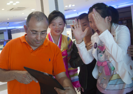 French tourist showing his ipad to North Korean saleswomen, Kangwon-do, Kumgang, North Korea