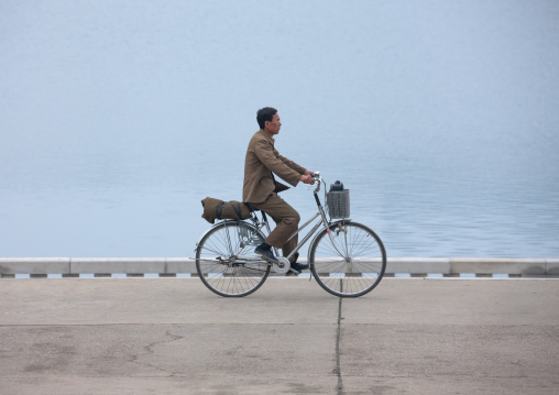 North Korean man riding a bicycle along Taedong river, Pyongan Province, Pyongyang, North Korea