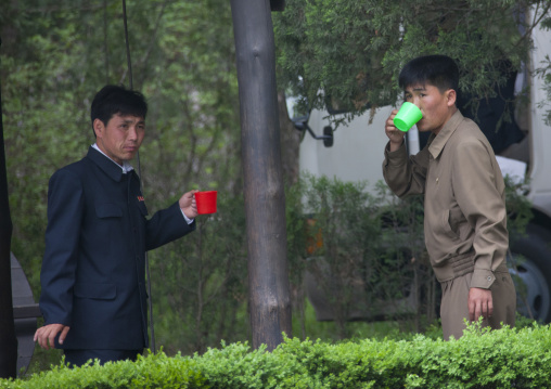 Two North Korean men drinking water in Mangyongdae which was the birthplace of North Korean leader Kim Il-sung, Pyongan Province, Pyongyang, North Korea