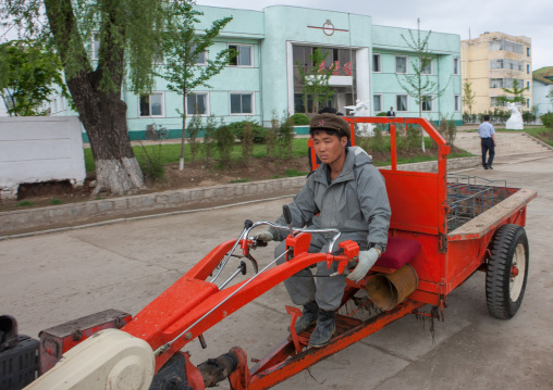 North Korean man driving a tractor in a village, South Pyongan Province, Chongsan-ri Cooperative Farm, North Korea