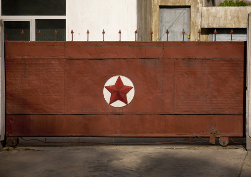 Rusty metal gate of a military camp with a red star, Pyongan Province, Pyongyang, North Korea