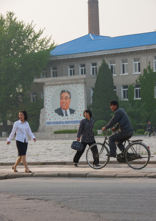North Korean people passing in front of a propaganda fresco with Kim il Sung, North Hwanghae Province, Kaesong, North Korea