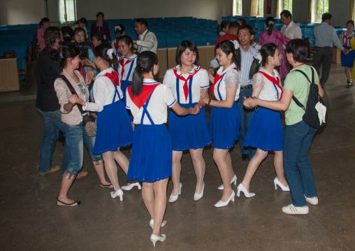 North Korean pioneer girls dancing with tourists in a school, Pyongan Province, Pyongyang, North Korea