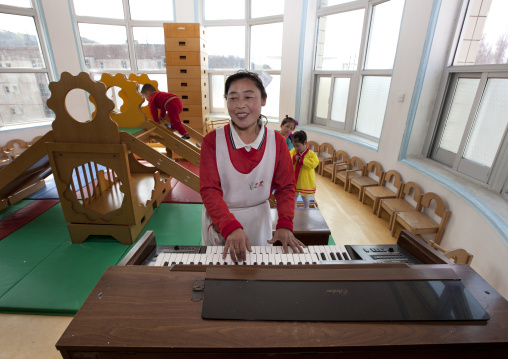Nurse playing organ in an orphanage, South Pyongan Province, Nampo, North Korea