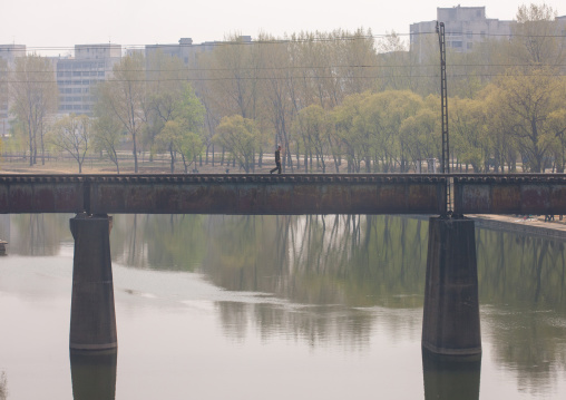 North Korean man crossing an empty railway bridge, Pyongan Province, Pyongyang, North Korea