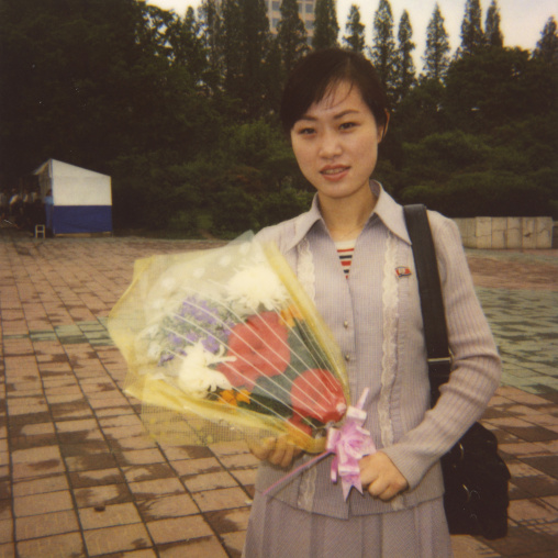 Polaroid of a North Korean woman with a bunch of flowers, Pyongan Province, Pyongyang, North Korea