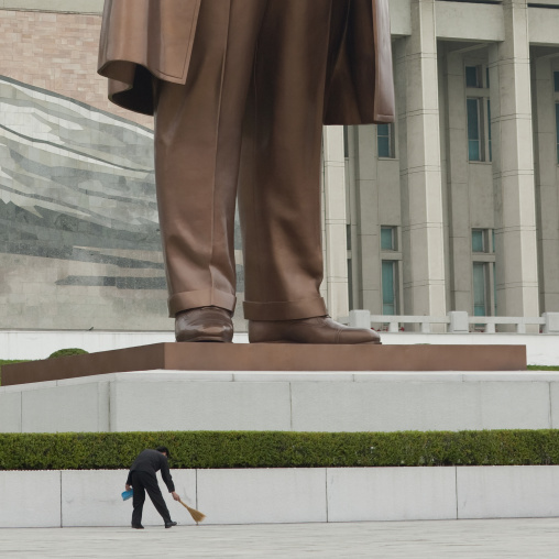 North Korean man sweeping in front of giant Kim il Sung statue in Mansudae Grand monument, Pyongan Province, Pyongyang, North Korea