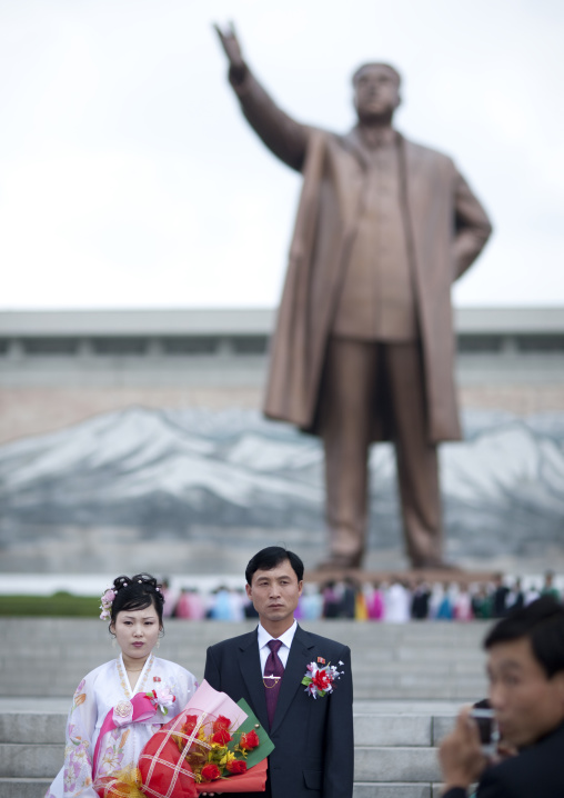 North Korean couple celebrating their wedding in front of Kim il Sung statue in Mansudae Grand monument, Pyongan Province, Pyongyang, North Korea